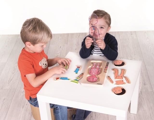 Deux enfants en train de jouer avec un puzzle éducatif - à la découverte du corps humain